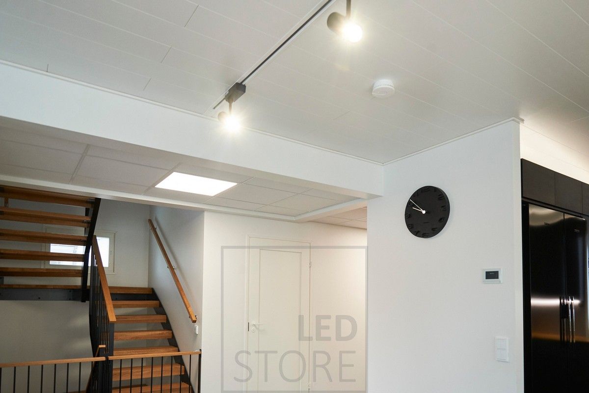 Mustat led kiskovalaisimet valaisemassa olohuonetta, käytävällä kattoikkunaa muistuttava paneeli-valaisin. Ledstore.fi